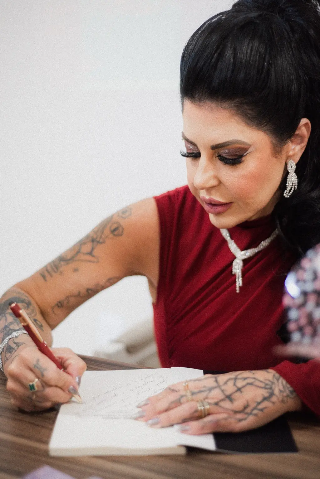 Dra. Alessandra Antonelli escrevendo à mão em uma mesa