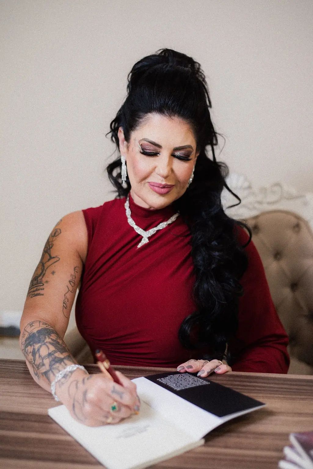 Dra. Alessandra Antonelli assinando um livro em uma mesa